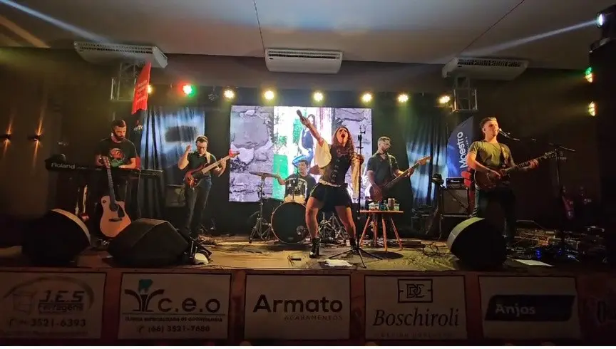 Lôids e banda completa no palco, com telão ao fundo