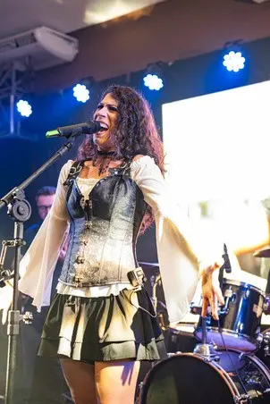 Lôids cantando no palco com a banda ao fundo