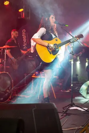 Lôids no palco com o violão, sob luz vermelha
